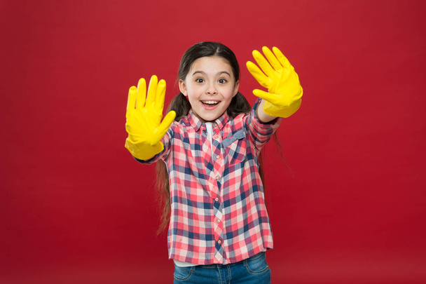 Feeling protected. Small girl rubber gloves for cleaning red background. Appreciate cleanliness. Clean house. Housekeeping duties. Spring cleaning. House cleaning service. Cleaning supplies - Foto, Bild