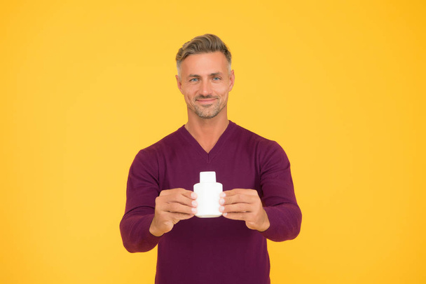 Exciting mens perfume. Happy man hold perfume bottle yellow background. Handsome guy presenting perfume. Eau de toilette. Cosmetic product. Cosmetics. Advertising perfume. Fragrance brand, copy space - Φωτογραφία, εικόνα