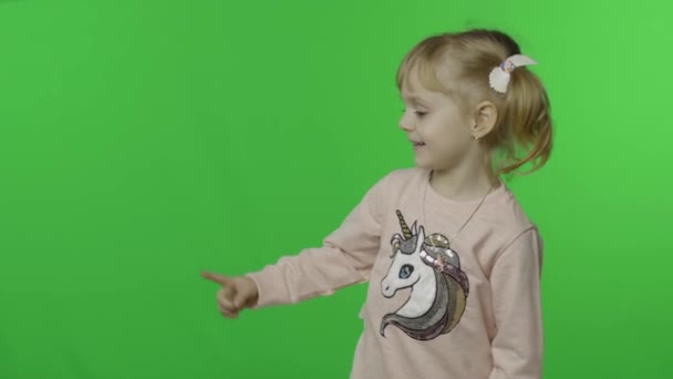 Mädchen im Einhorn-Sweatshirt zeigt emotional mit den Händen auf etwas - Filmmaterial, Video