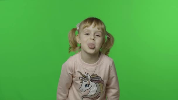 Дівчинка в спітнілому сорочці показує язик і посмішку. Щаслива дитина. Chroma Key - Кадри, відео