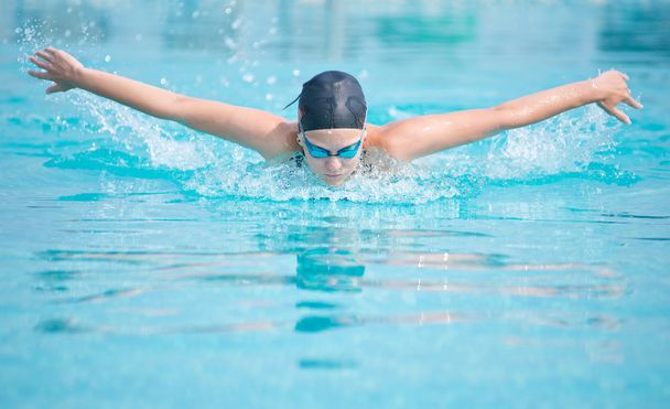 Young girl swimming butterfly stroke style - Foto, afbeelding