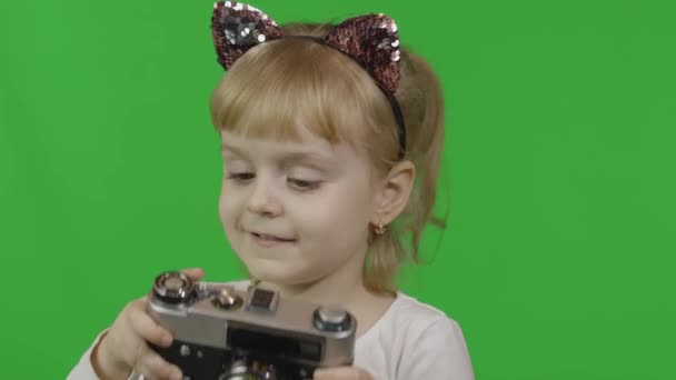 Κορίτσι με κεφαλόδεσμο που τραβάει φωτογραφίες σε μια παλιά ρετρό φωτογραφική μηχανή. Κλειδί χρωμίου - Πλάνα, βίντεο