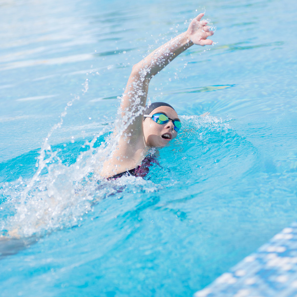 Woman in goggles swimming front crawl style - Fotoğraf, Görsel