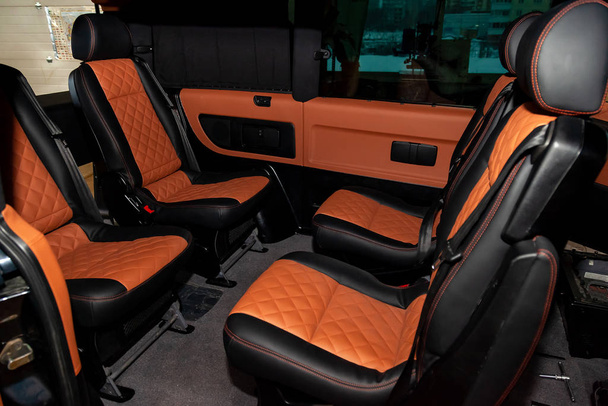 Чотири задні сидіння в мікроавтобусі розташовані один до одного і сидять
 - Фото, зображення