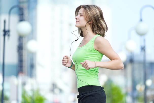 Woman jogging in city street park. - Фото, изображение