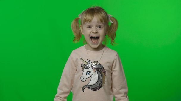 Menina em camisola unicórnio fazer rostos e gritos. Criança feliz. Chave Chroma
 - Foto, Imagem