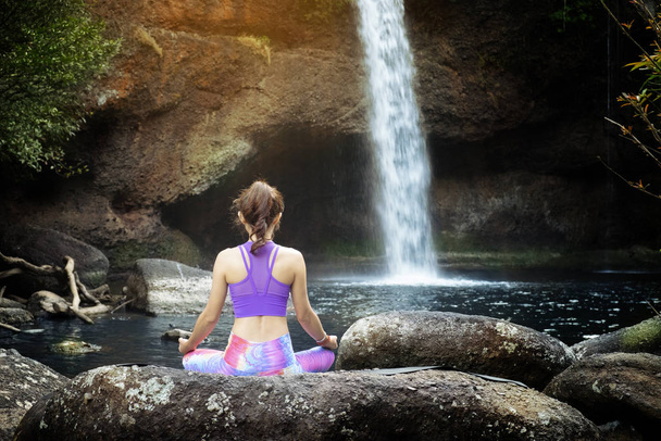 женщина практикует йогу перед водопадом
 - Фото, изображение