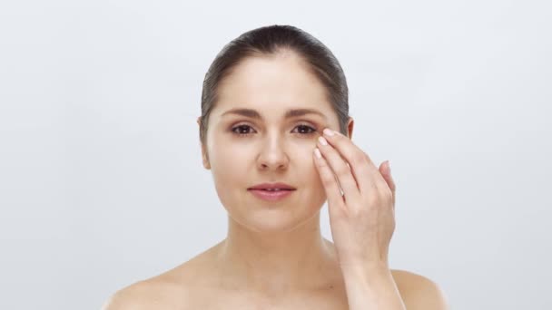 Studio portrait of young, beautiful and natural woman applying skin care cream. Face lifting, cosmetics and make-up concept. - Séquence, vidéo