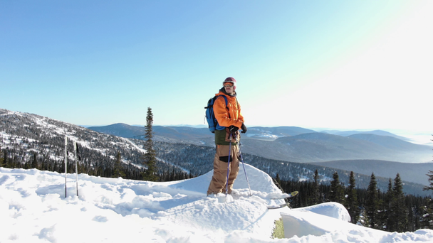 cara com equipamento de esqui fica na borda do monte nevado superior
 - Filmagem, Vídeo