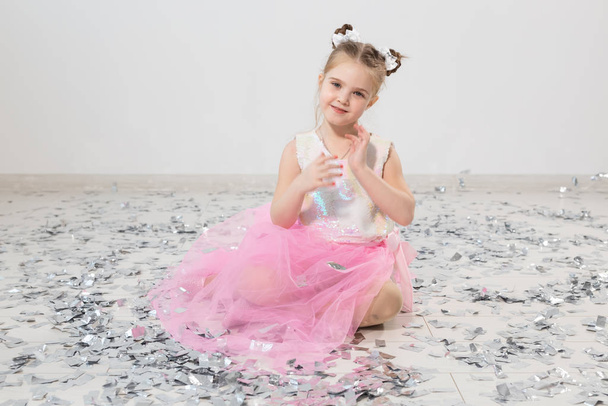 Party, holidays, birthday, new year and celebration concept - Cute child with confetti. - Fotografie, Obrázek