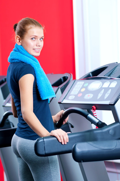 Young woman at the gym run on on a machine - Fotó, kép