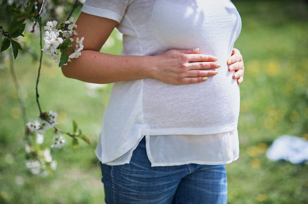 Rajattu kuva kaunis raskaana oleva nuori nainen koskettaa hänen paljain vatsa
 - Valokuva, kuva