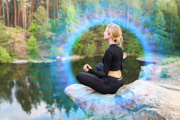 Piękna młoda kobieta medytująca nad jeziorem - Zdjęcie, obraz
