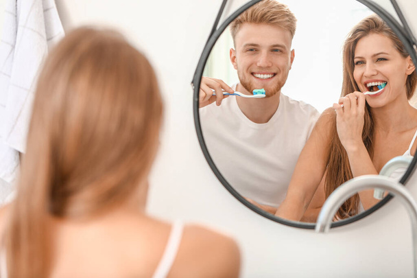 Pareja joven cepillándose los dientes en casa
 - Foto, imagen