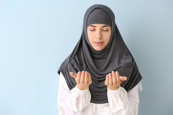 Портрет молящейся мусульманки на цветном фоне
 - Фото, изображение