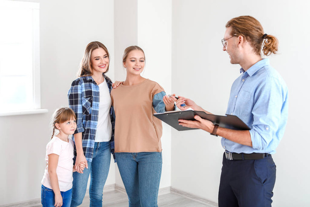 Real estate agent giving a key from new house to lesbian family - Foto, afbeelding