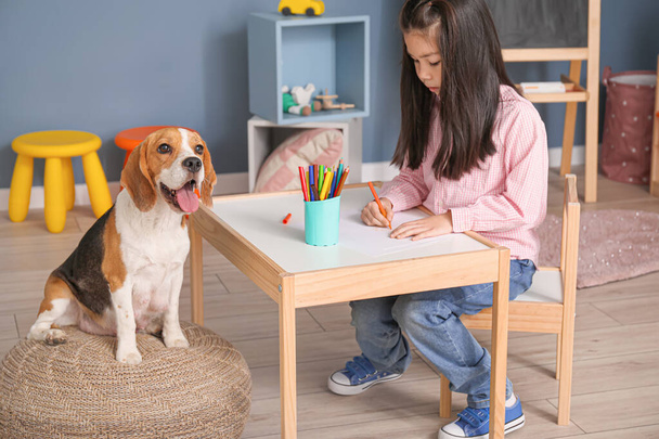 kleine asiatische Mädchen mit niedlichen Beagle Hund Zeichnung zu Hause - Foto, Bild