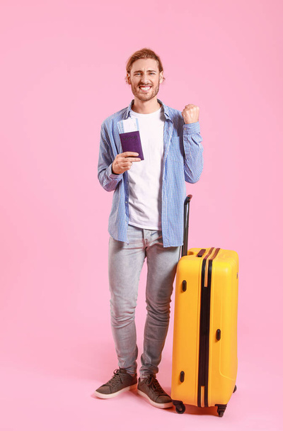 Young tourist with luggage on color background - Fotografie, Obrázek