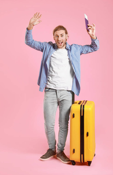 Joven turista con equipaje sobre fondo de color
 - Foto, Imagen