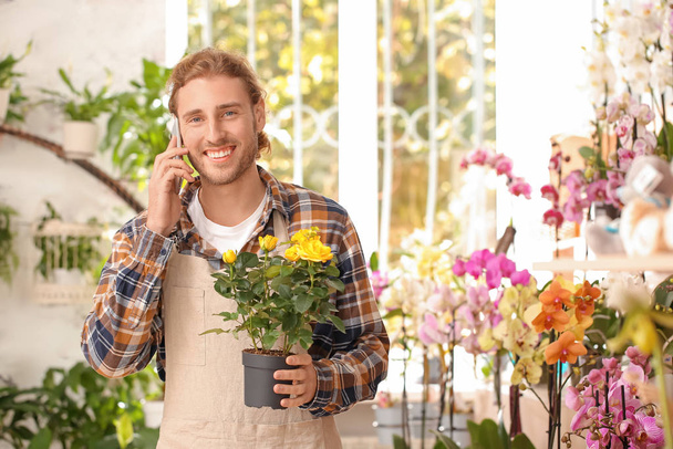 Retrato de florista masculino hablando por teléfono en la tienda
 - Foto, Imagen