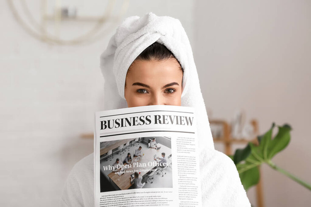 Beautiful young woman with newspaper in bathroom - Zdjęcie, obraz
