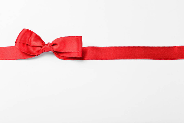 Beautiful red ribbon and bow on white background - 写真・画像