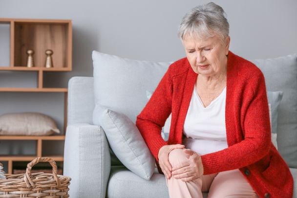 Starší žena trpící bolestí v kolenou doma - Fotografie, Obrázek