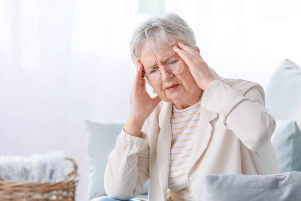 Mujer mayor que sufre de dolor de cabeza en casa - Foto, Imagen