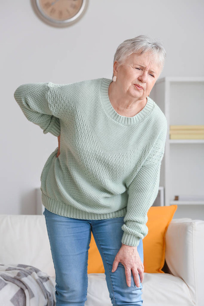 Seniorin leidet zu Hause unter Rückenschmerzen - Foto, Bild