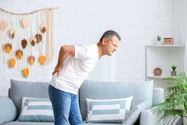 Mature man suffering from back pain at home - Fotoğraf, Görsel