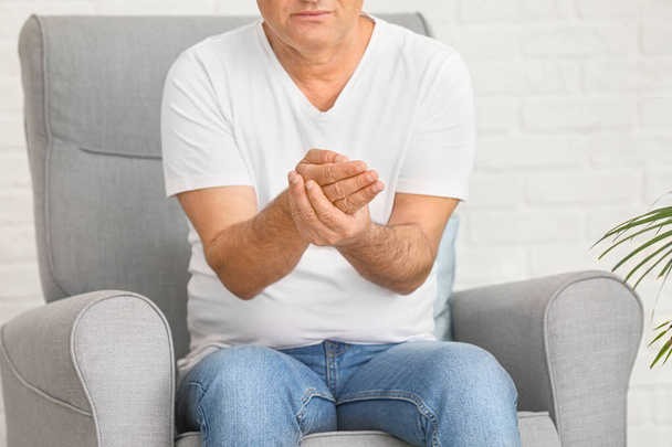 Mature man suffering from pain in wrist at home - Photo, Image