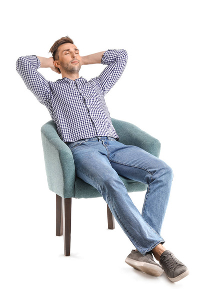 Handsome man sitting in armchair on white background - Foto, afbeelding