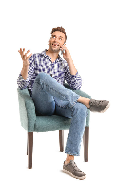 Beau homme parlant par téléphone portable tout en étant assis dans un fauteuil sur fond blanc
 - Photo, image