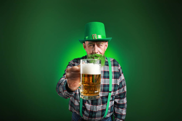Funny mature man with glass of beer on dark background. St. Patrick's Day celebration - Foto, Imagen