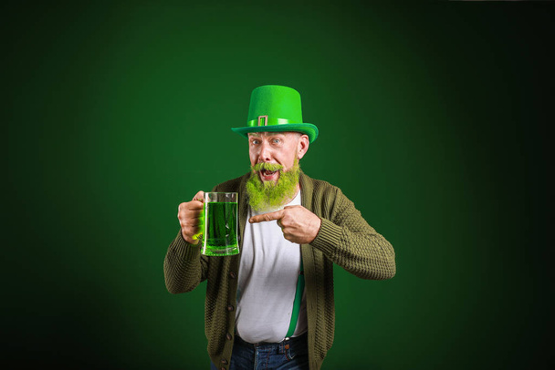 Funny mature man with glass of beer on dark background. St. Patrick's Day celebration - Fotografie, Obrázek