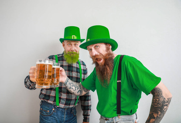 ビールグラスを背景に髭を生やした男たち。聖パトリックの日のお祝い - 写真・画像