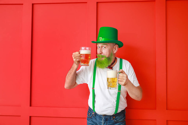 Funny mature man with glasses of beer on color background. St. Patrick's Day celebration - Fotografie, Obrázek
