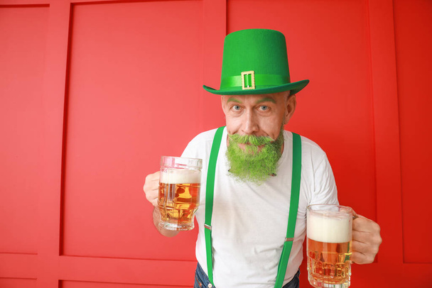 Funny mature man with glasses of beer on color background. St. Patrick's Day celebration - Fotoğraf, Görsel