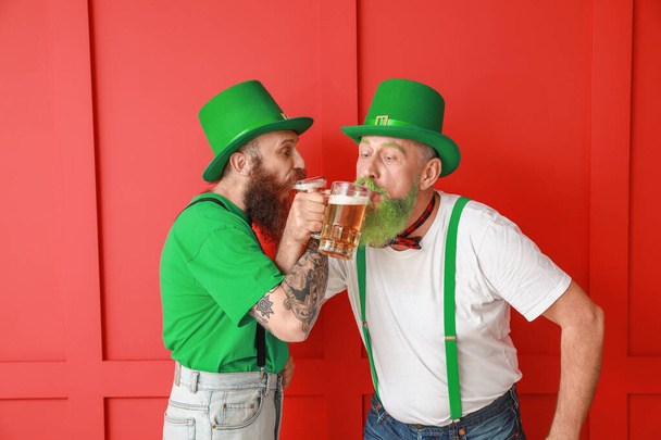 Hommes barbus avec des verres de bière sur fond de couleur. Célébration de la Saint Patrick
 - Photo, image