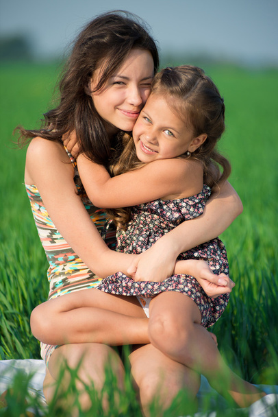 Happy girls on green grass embrace - Fotografie, Obrázek
