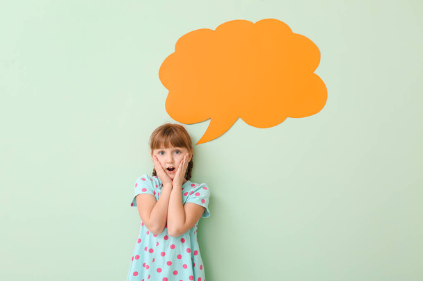 überraschte kleines Mädchen mit leerer Sprechblase auf farbigem Hintergrund - Foto, Bild