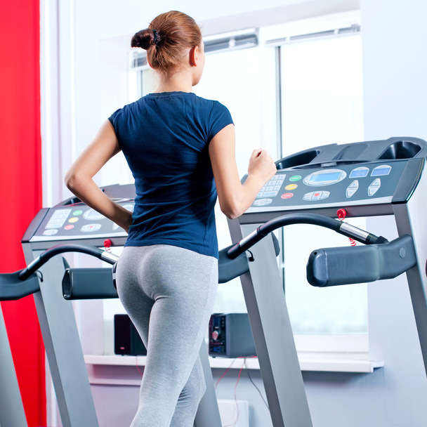Young woman at the gym run on on a machine - Foto, Bild
