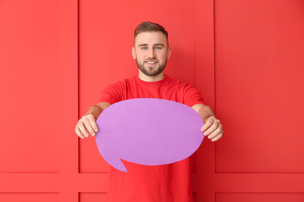 Young man with blank speech bubble on color background - Foto, Imagen