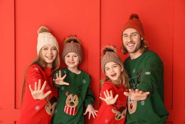 Happy family in Christmas clothes on color background - Фото, изображение