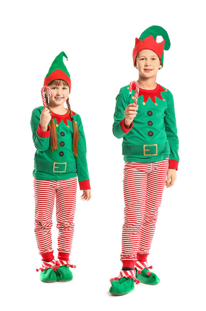 Elf kostümü giymiş küçük çocuklar ve beyaz arka planda şeker kamışları. - Fotoğraf, Görsel