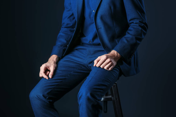 Homem em roupas azuis elegantes no fundo escuro
 - Foto, Imagem