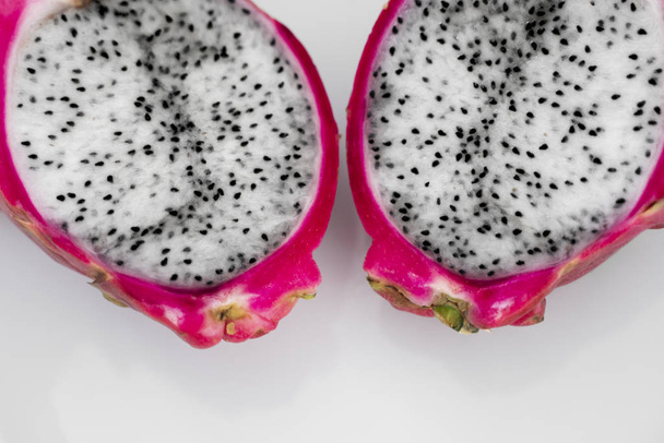 Dragon fruit. Vibrant Dragon Fruit on white background. Sliced white dragon fruit or pitaya on white plate on the table, close-up. Tropical and exotic fruits. Healthy and vitamin food concept. - Photo, Image