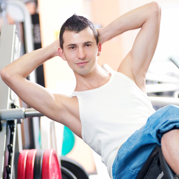 Young man doing exercises at gym - Foto, imagen