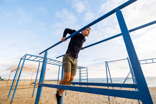 Young fit male training do exercises outdoor on the beach - Foto, Imagem