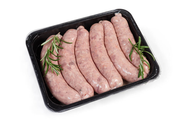 Saucisses de porc non cuites avec brins de romarin dans un emballage alimentaire en plastique
 - Photo, image